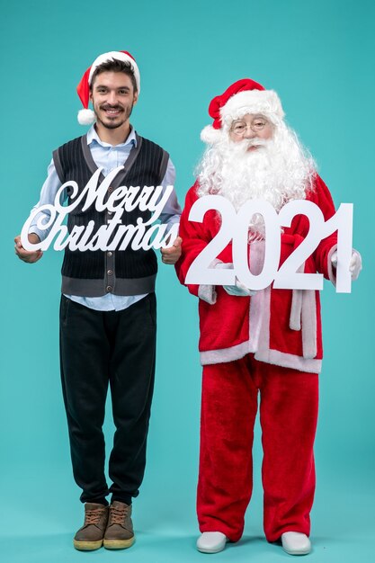 Front view santa claus with young male holding merry christmas and writings on a blue background