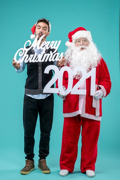 Front view santa claus with young male holding merry christmas and writings on blue background