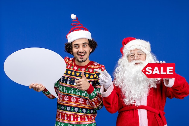 Free Photo front view santa claus with young male holding white sign and sale writing