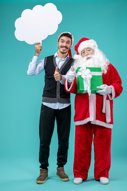 Front view santa claus with young male whos holding white cloud sign on blue background