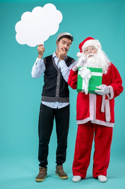 Front view santa claus with young male whos holding white cloud sign on the blue background