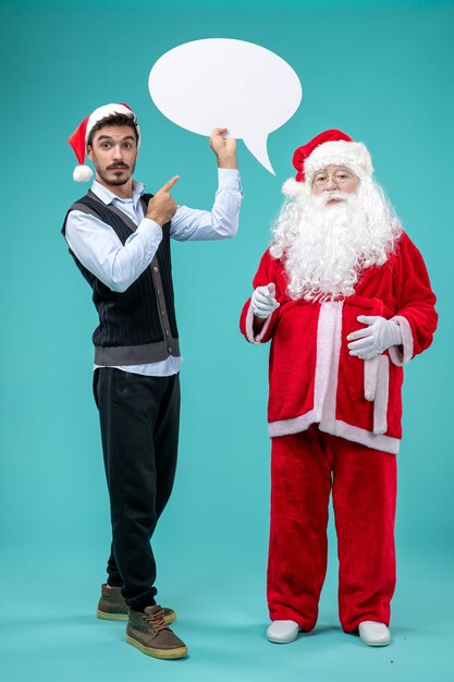 Front view santa claus with young male whos holding white sign on a blue background