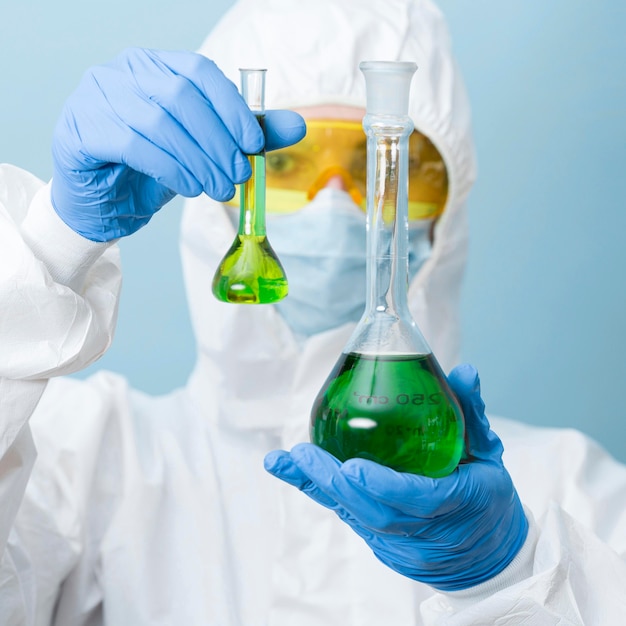 Front view scientist holding green chemicals