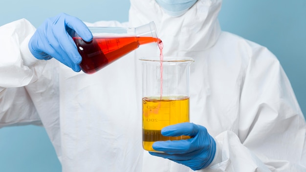 Free photo front view scientist mixing different chemicals