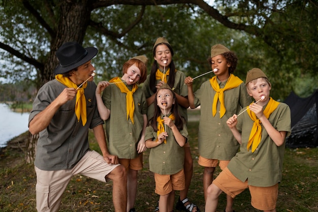 Free photo front view scouts eating marshmallows