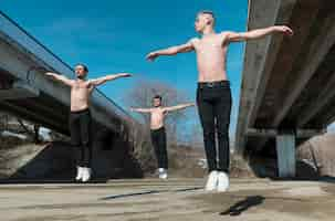 Free photo front view of shirtless hip hop performers dancing outside