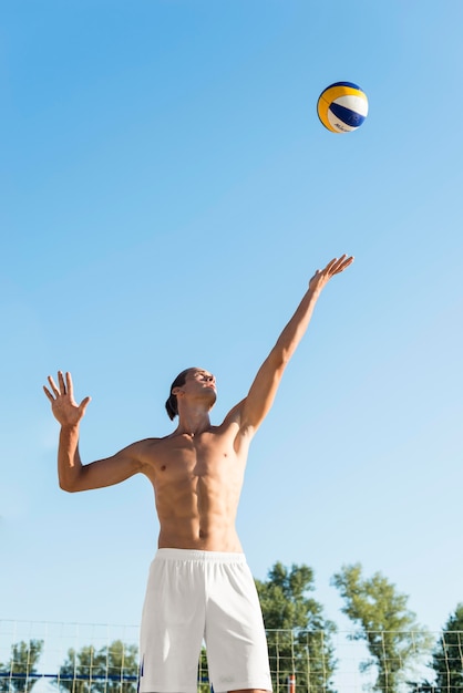 Free Photo front view of shirtless male volleyball player serving ball