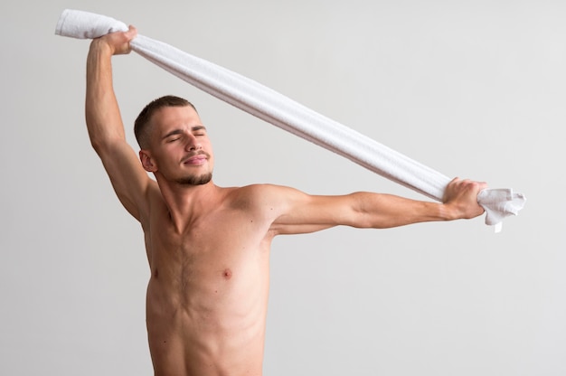 Front view of shirtless man posing with towel