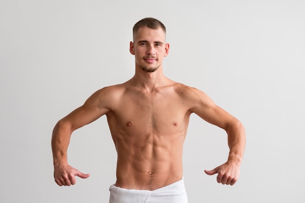 Front view of shirtless man showing off his body