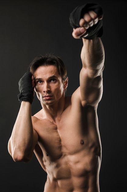 Front view of shirtless muscled man with boxing gloves