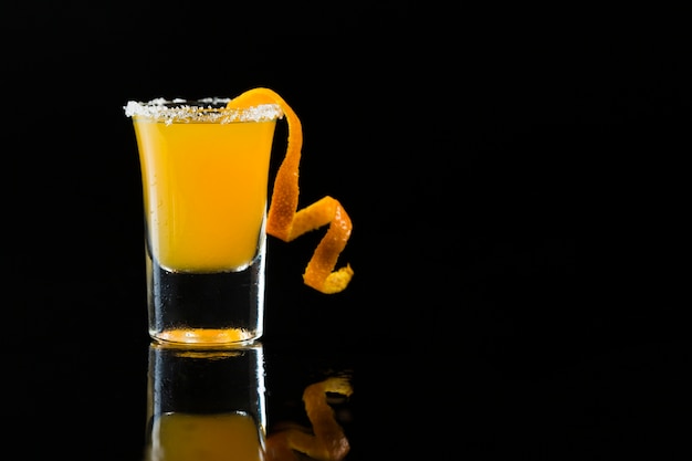 Front view of shot glass with orange cocktail