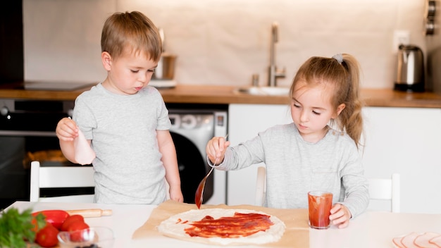 Front view of siblings cooking at home