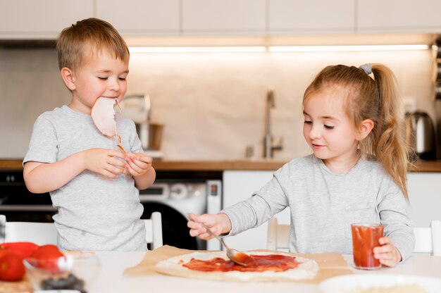 Free photo front view of siblings cooking at home