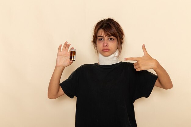 Front view sick young female feeling ill and holding pills on a white surface