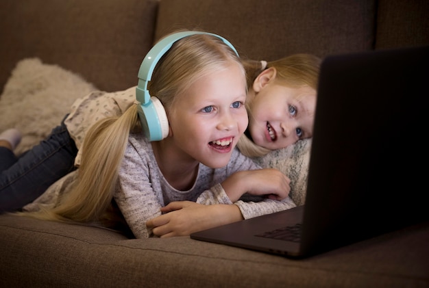 Front view of sisters on couch with a laptop