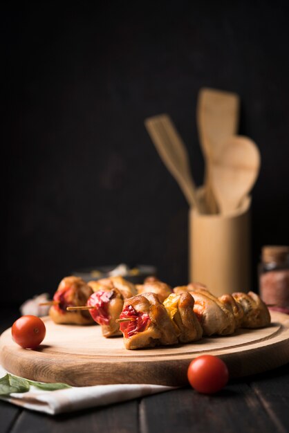 Front view skewers on wooden board with tomatoes