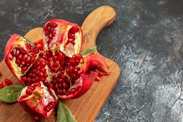 Front view sliced pomegranates fresh red fruits on light floor fruit red fresh