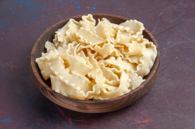 Front view sliced raw dough inside brown plate on dark space