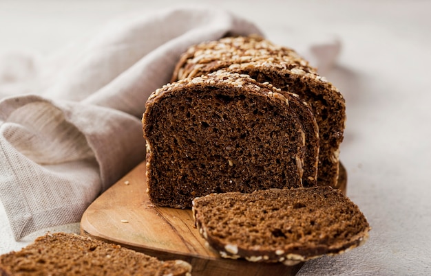 Front view slices of bread with grains on wooden board