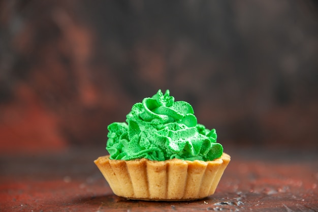 Front view small tart with green pastry cream on dark red table with copy space