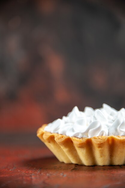 Front view small tart with pastry cream on dark red table with copy space