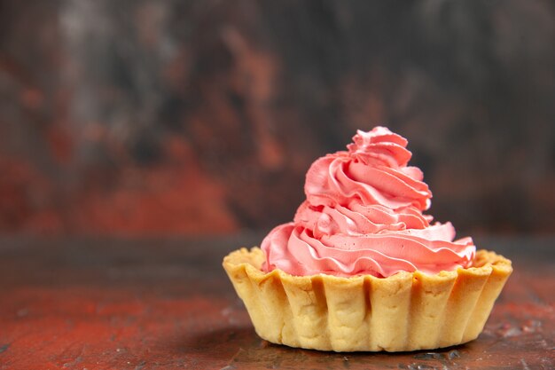 Front view small tart with pink pastry cream on dark red table free place