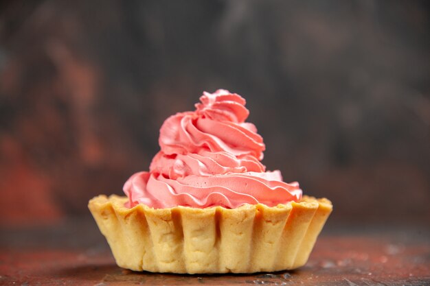 Front view small tart with pink pastry cream on dark red table