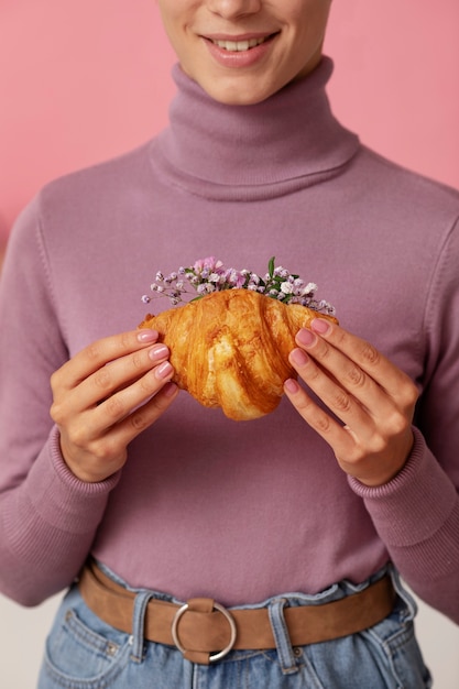 Free Photo front view smiley adult holding croissant