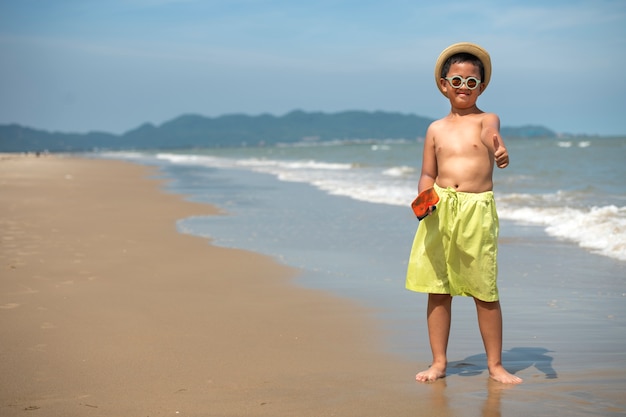 Free photo front view smiley boy on beach