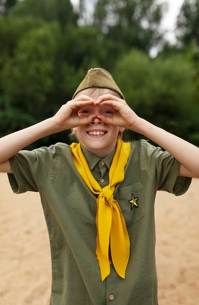 Free photo front view smiley boy scout outdoors