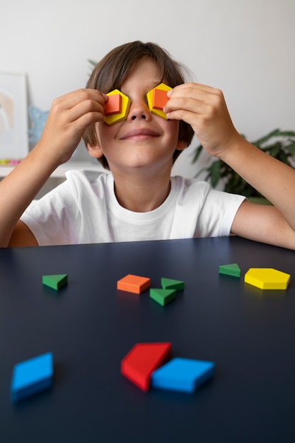 Free Photo front view smiley boy with puzzle pieces