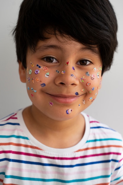 Front view smiley boy with stickers on face