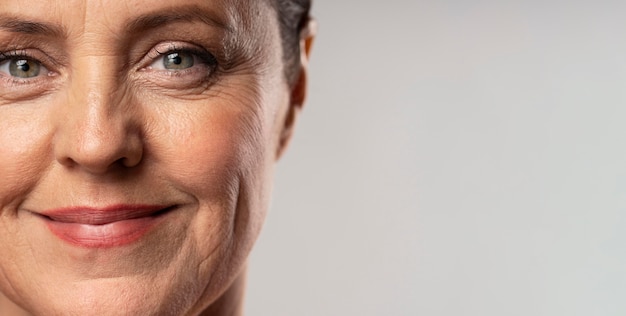 Front view of smiley elder woman posing with make-up on and copy space