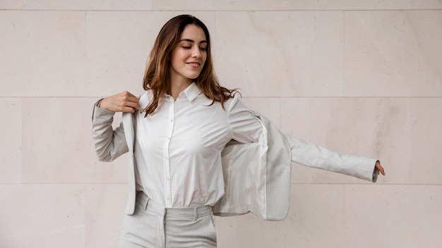 Free photo front view of smiley elegant businesswoman putting on a suit