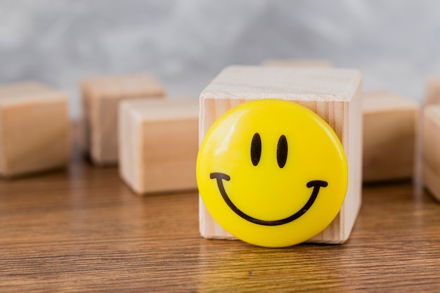 Free photo front view of smiley face on wooden block