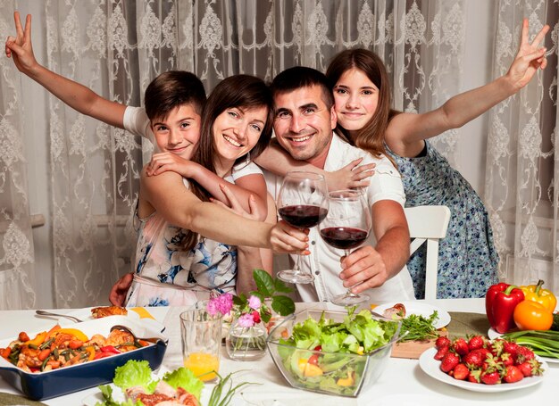 Front view of smiley family at dinner table