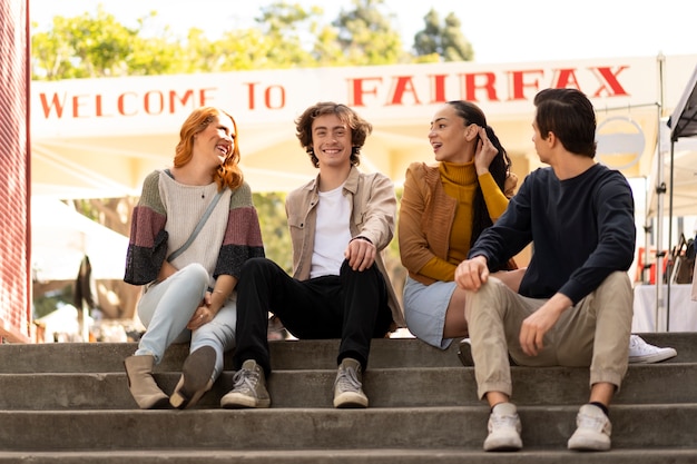 Free photo front view smiley friends sitting on stairs