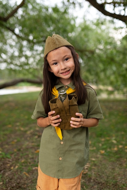 Free photo front view smiley girl scout in nature