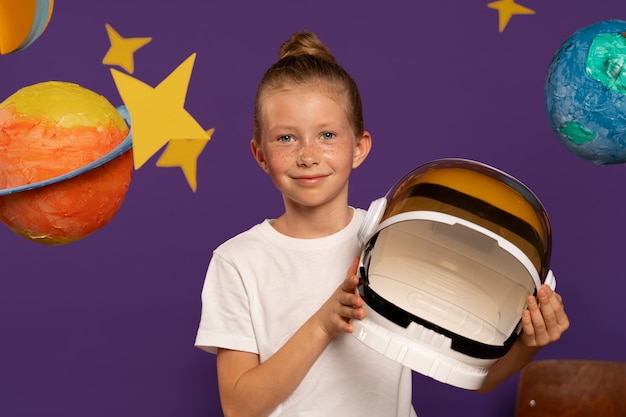 Free photo front view smiley kid holding helmet