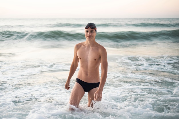 Front view of smiley male swimmer in the ocean