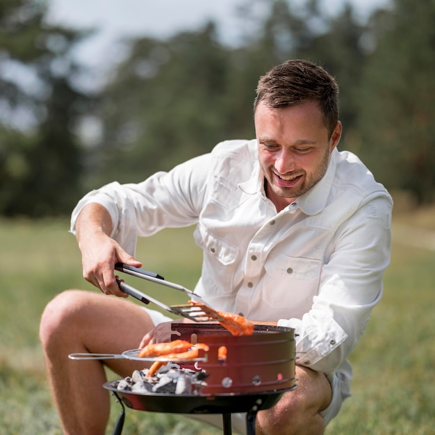 Free photo front view of smiley man attending the barbecue outdoors