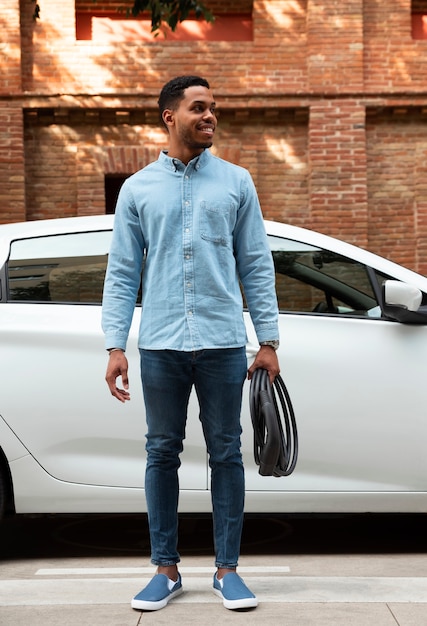 Front view smiley man holding charging cable