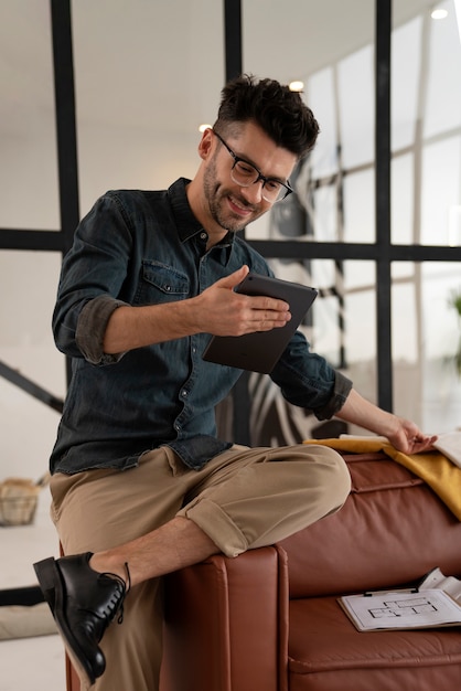 Free photo front view smiley man holding tablet