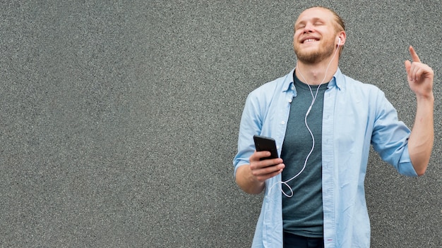 Free photo front view of smiley man listening to music