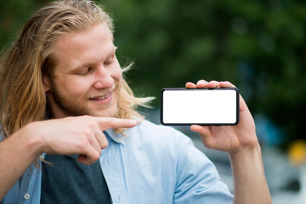 Front view of smiley man pointing at phone