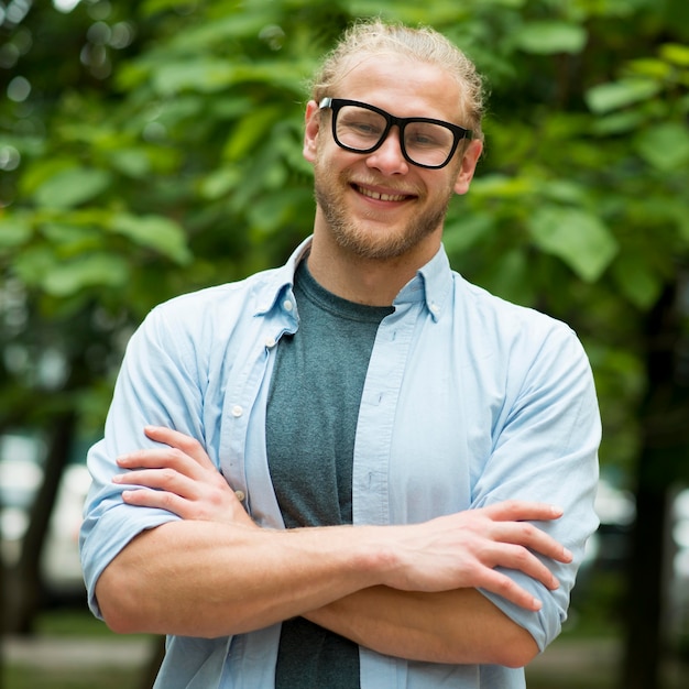 Free photo front view of smiley man posing outdoors