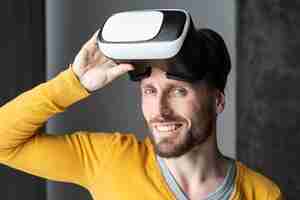 Free photo front view of smiley man posing with virtual reality headset