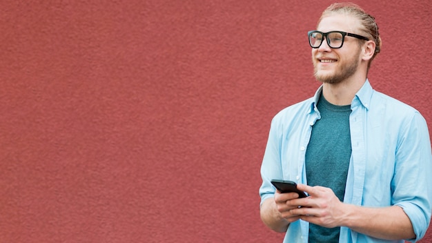 Front view of smiley man with copy space and smartphone