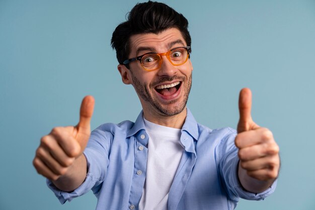 Front view of smiley man with glasses showing thumbs up