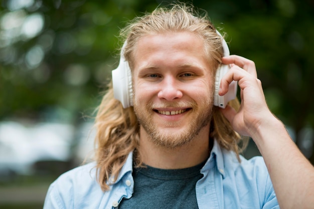 Free Photo front view of smiley man with headphones outdoors